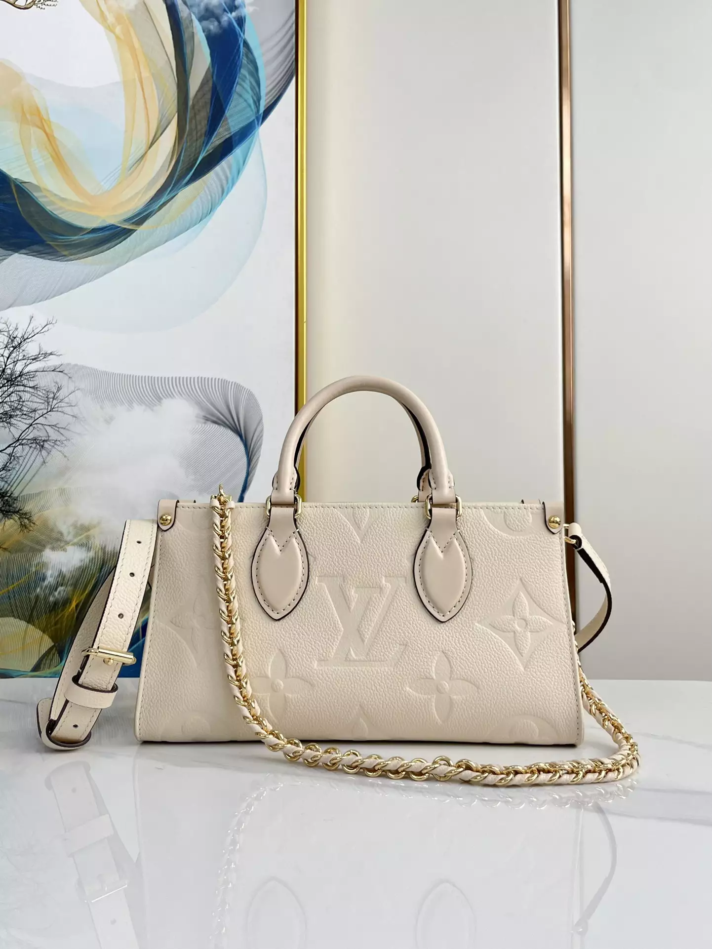 OnTheGo East West Monogram Empreinte Creme Leather