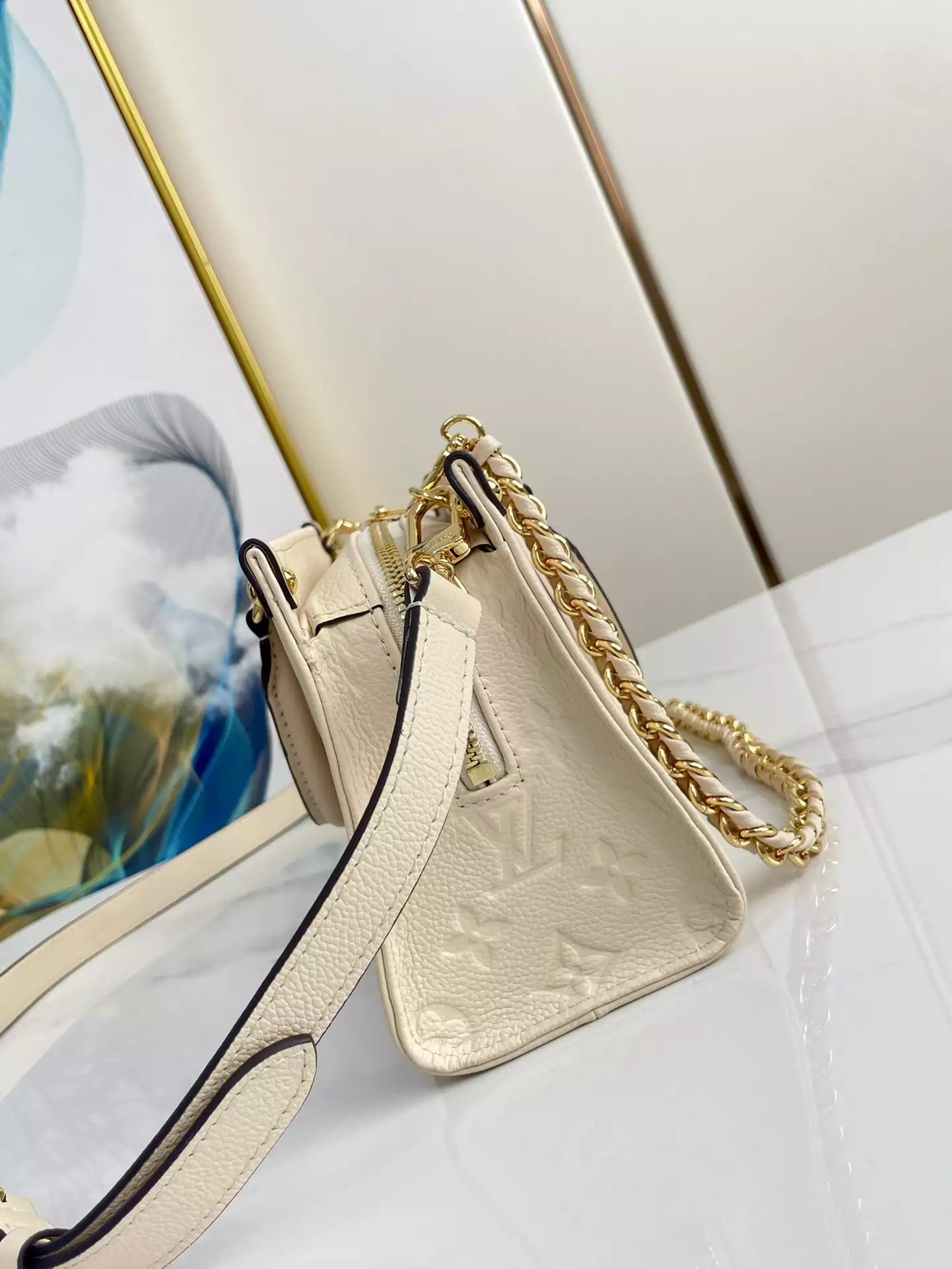 OnTheGo East West Monogram Empreinte Creme Leather